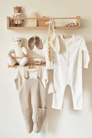Children's knitted clothes on hanger. Jacket, jumper, hat, shoes. toys. Children's room, nursery.の写真素材