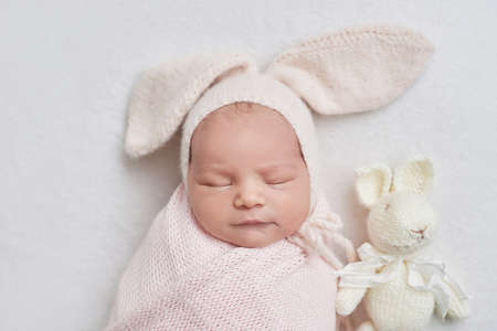 Newborn baby girl in bunny hat. Healthy child. happy motherhood and parenting.の写真素材
