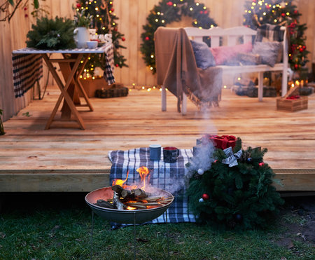 New Year and Christmas backyard decorations. Christmas tree, wreath and gifts. Winter holidays and celebrations. Bonfire and fire. Christmas barbecue.の写真素材