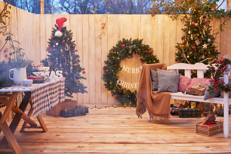 New Year and Christmas backyard decorations. Christmas tree, wreath and gifts. Winter holidays and celebrations.の写真素材