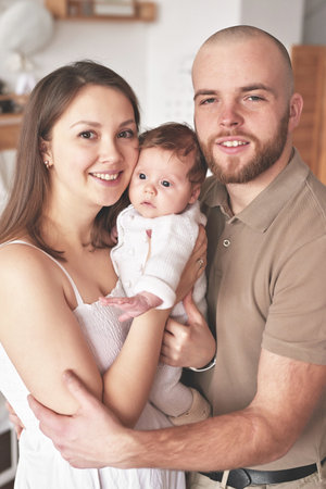 young beautiful family. mother and father hold newborn baby. happy parents and child. Mother's and...