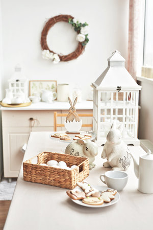 Easter table setting with eggs, rabbits and wicker basket with cookies