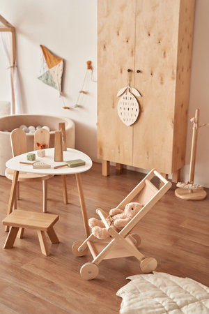 Children's educational wooden toys. Nursery decor. Scandinavian style playroom. Wooden stroller.の写真素材