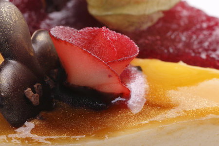a piece of cheese cake with chocolate and marzipan rosesの写真素材