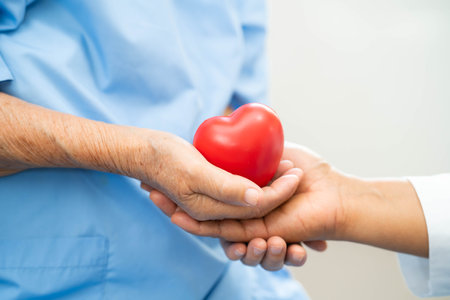 Asian doctor give red heart to elderly woman in her hand, heart Attack.の写真素材