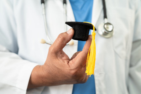 Asian doctor holding graduation gap hat, education medicine.の写真素材