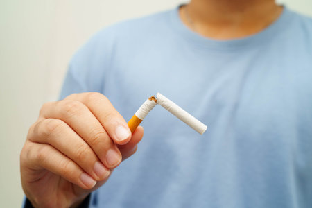 Quit smoking, Asian man breaking destroy cigarette in hand.の写真素材