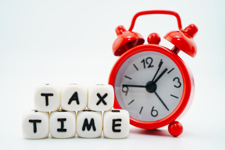Tax time reminder sticky note on red alarm clock on white with copy space.の写真素材