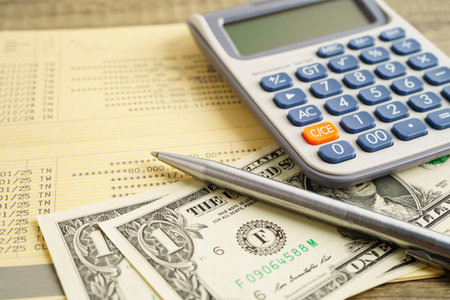 Coins with calculator and pen on finance.