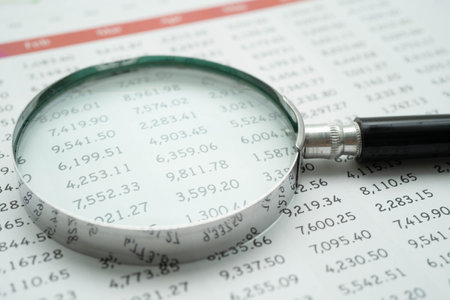 Magnifying glass on charts graphs paper. Financial development, Banking Account, Statistics,...