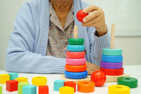 Asian elderly woman playing enhancing skill board game.の写真素材