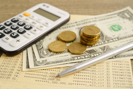 Coins money with calculator and pen on bookbank finance.の写真素材