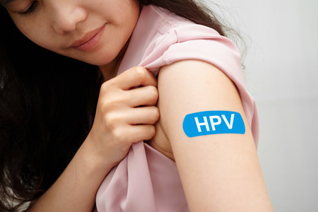 HPV, Human papillomavirus, Asian young woman receiving vaccine with blue bandage.