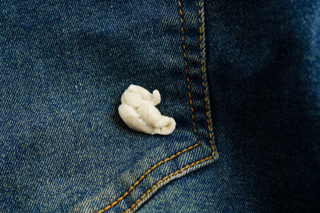 Dirty chewing gum stain removal on cloth jean to wash with washing powder, cleaning housework.