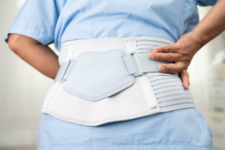 Asian woman patient wearing back pain support belt for orthopedic lumbar with walker.