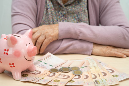 Retired elderly woman counting coins money with piggy bank and worry about monthly expenses and...