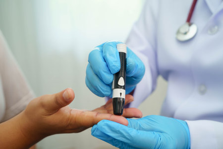Asian woman self testing to check blood sugar level diabetes by digital lancet on finger at home.