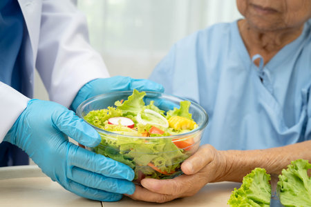 Asian Nutritionist holding healthy food for patient in hospital, nutrition and vitamin.の写真素材