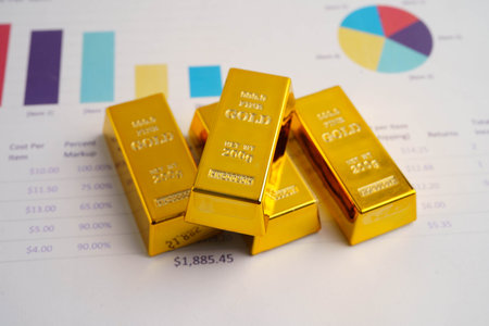 Gold bars on graph paper, finance trading investment business currency.