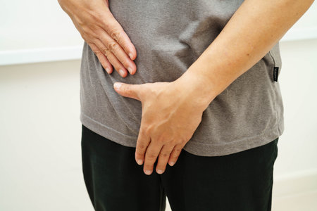 Hernia, Asian man stomach ache, abdominal pain and urology problem health.