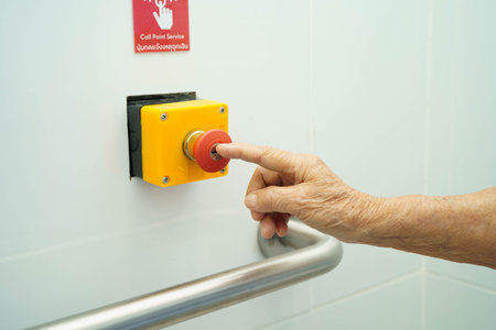 Asian elderly woman press emergency button in toilet.の写真素材