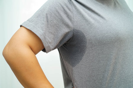 Sweaty underarms, Asian woman with sweat on clothes under armpit.
