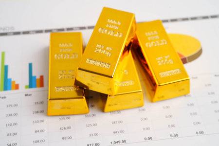 Gold bars on US dollar banknote money, finance trading investment business currency concept.