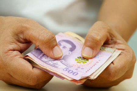 Asian woman counting Thai baht banknote money and holding in hand, investment economy, accounting...