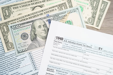 Tax form 1040 U.S. Individual Income Tax Return with dollar banknotes money.