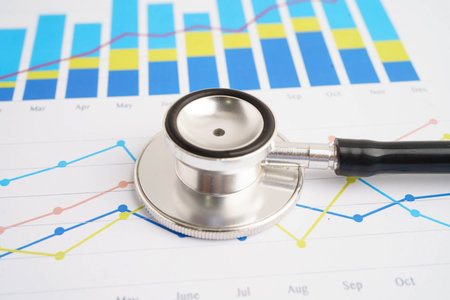 Stethoscope and US dollar banknotes on chart or graph paper, Financial, account, statistics and...