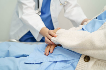 Asian doctor checking and treat elderly woman patient health in hospital.