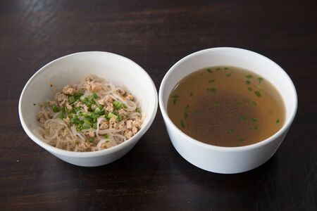 Noodles  in bowl on wooden background, selective focus. Asian meal on a table
