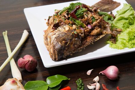 Fried fish with fresh thai herbsの写真素材