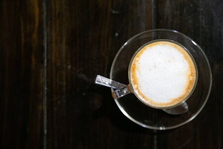 Thai hot milk tea on black wooden table background in top viewの写真素材