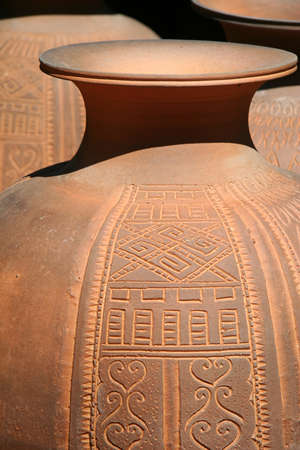 Thai earthenware handmade carved pots arranged in a pattern of Thai artの写真素材