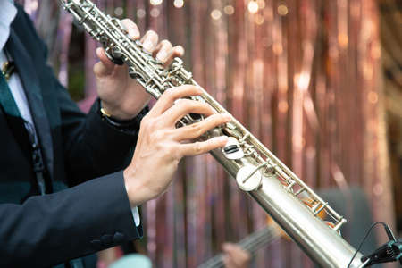 Clarinet player holding a metal transverse flute in his hands.