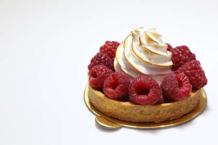 Meringue pie with raspberries on a white plate. Pie with bizet and fresh berries.