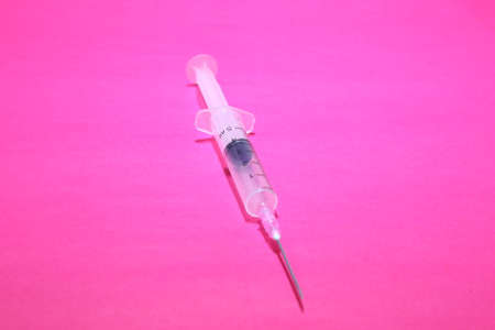 Syringe closeup isolated on pink background