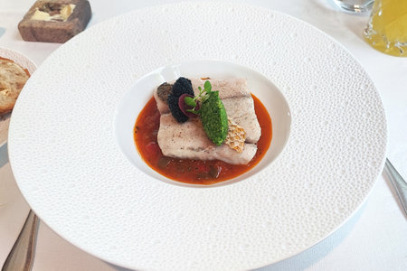 Prepared white fish fillet served with grilled vegetables
