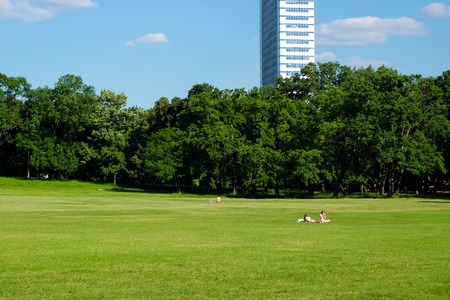 Sunny day in city park in Budapest with two people on green grassのeditorial素材