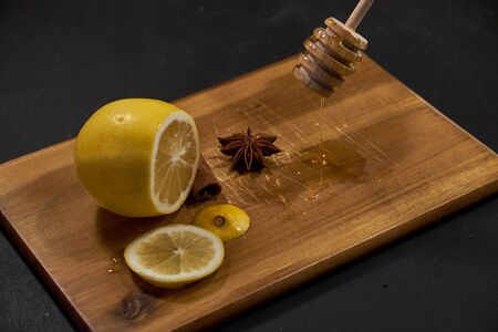 Lemon, spices and honey on cutting boardの写真素材
