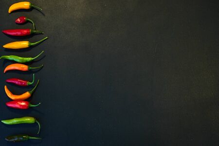 Row of chili with copyspace on black backgroundの写真素材