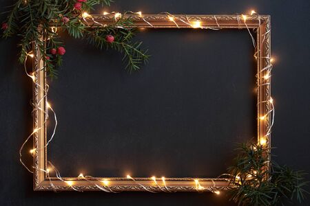 Frame with Christmas lights and decor on black with copyspaceの写真素材