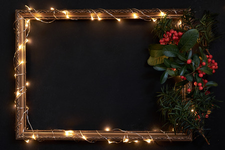 Frame with Christmas lights and decor on black with copyspaceの写真素材