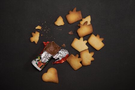 Chrismas cookies and chocolate pieces on blackの写真素材