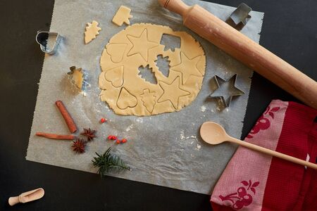 Top view of cookie dough, cookie cutters, rolling pin, cinnamon, towelの写真素材