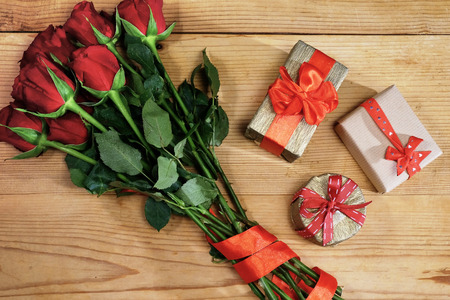 Bunch of red roses with ribbon and three gift boxesの写真素材
