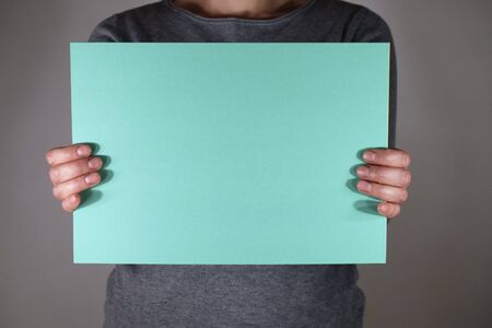 Two hands holding blue paper sheetの写真素材