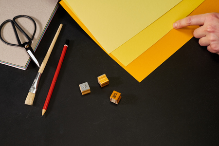 Hand choosing yellow shade with creativity tools on blackboardの写真素材