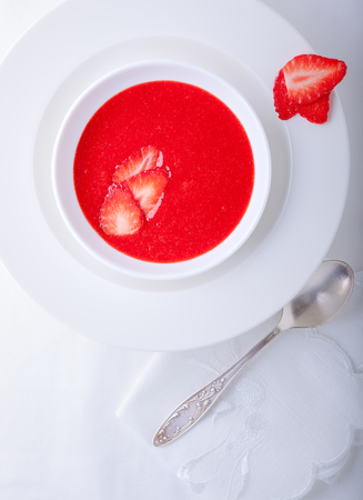 Strawberry soup served on a white plate.の写真素材